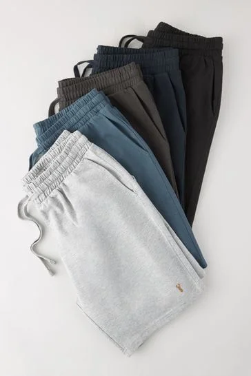 Neatly folded linen shirts, shorts, and summer dresses